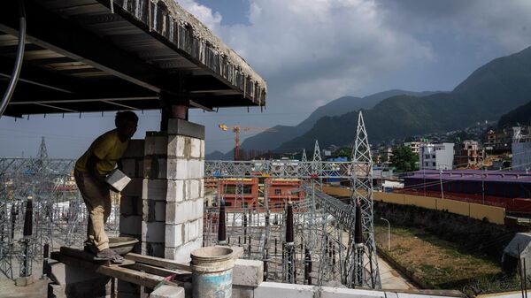 A laborer works at a construction site next to a power station at Matatirtha on the outskirts of Kathmandu, Nepal, Friday, May 31, 2024. Nepal’s abundant hydroelectric power is helping the Himalayan nation cut its oil imports and clean up its air, thanks to a boom in sales of electric vehicles. - Sputnik भारत