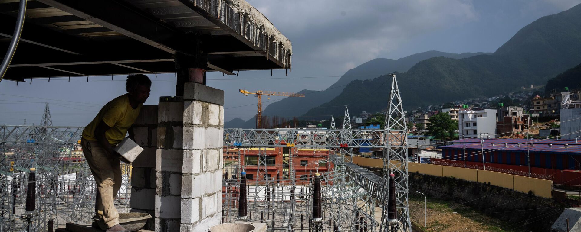 A laborer works at a construction site next to a power station at Matatirtha on the outskirts of Kathmandu, Nepal, Friday, May 31, 2024. Nepal’s abundant hydroelectric power is helping the Himalayan nation cut its oil imports and clean up its air, thanks to a boom in sales of electric vehicles. - Sputnik भारत, 1920, 06.06.2026