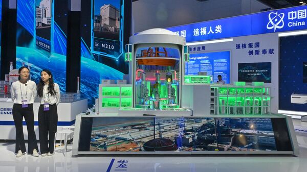Women stand next to a model of a nuclear thermal reactor (C) during the 26th China Beijing International High-Tech Exhibition at the National Convention Center in Beijing on July 16, 2024. (Photo by ADEK BERRY / AFP) - Sputnik India