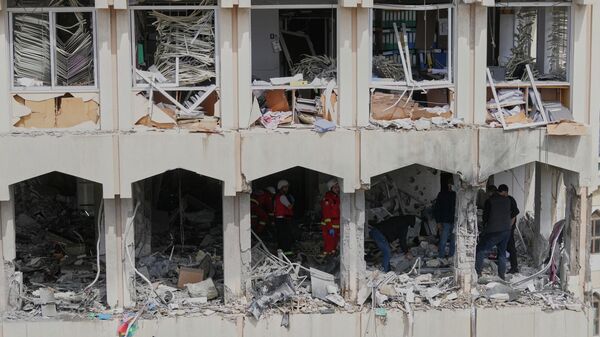 Security officers check the damage at a building struck by an Israeli airstrike in the southern port city of Sidon, Lebanon, Friday, March 6, 2026. (AP Photo/Mohammed Zaatari) - Sputnik India