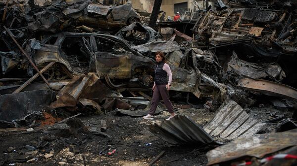 A resident walks near charred cars, at the site of Wednesday's Israeli airstrike, in Beirut, Lebanon, Friday, April 10, 2026. - Sputnik India