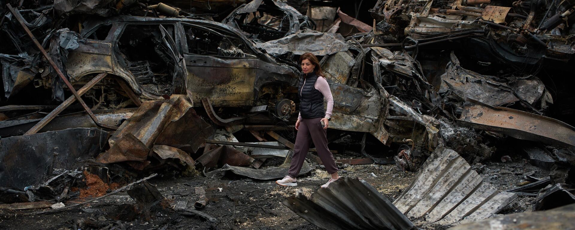 A resident walks near charred cars, at the site of Wednesday's Israeli airstrike, in Beirut, Lebanon, Friday, April 10, 2026. - Sputnik India, 1920, 14.06.2026