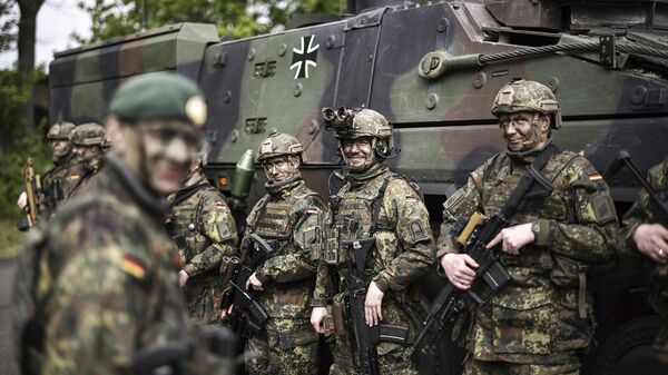 Soldiers of the German forces, Bundeswehr, stand in front of a Boxer military vehicle, a new type of armoured personnel carrier, at the Julius Leber Barracks in Berlin, Germany, Wednesday, April 24, 2024.  - Sputnik India