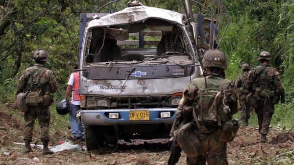 Soldiers walk past a wrecked military truck destroyed by a bomb in Tulua, southwestern Colombia, Thursday, May 10, 2007. A roadside bomb planted by leftist rebels killed at least 10 soldiers who were patrolling the area, authorities said. - Sputnik India