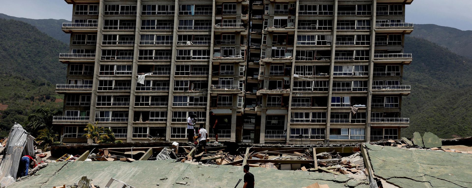 People inspect the rubble of a collapsed building after earthquakes hit the country, in La Guaira, Venezuela, June 25, 2026. REUTERS/Gaby Oraa - Sputnik India, 1920, 26.06.2026