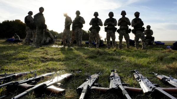 Weapons lie on the ground as Ukrainian personnel take a break during training  - Sputnik India