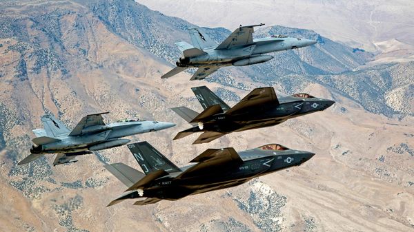In this Sept. 3, 2015, file photo provided by the US Navy, F-35C Lightning IIs, attached to the Grim Reapers of Strike Fighter Squadron (VFA) 101, and F/A-18E/F Super Hornets attached to the Naval Aviation Warfighter Development Center (NAWDC) fly over Naval Air Station Fallon's (NASF) Range Training Complex near Fallon - Sputnik India