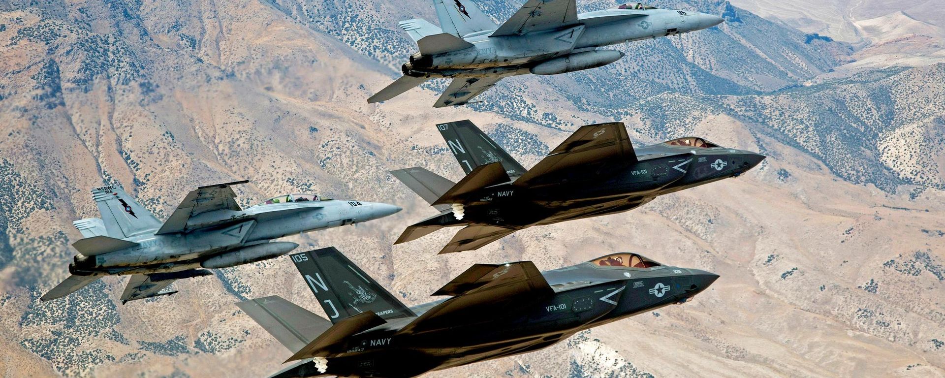 In this Sept. 3, 2015, file photo provided by the US Navy, F-35C Lightning IIs, attached to the Grim Reapers of Strike Fighter Squadron (VFA) 101, and F/A-18E/F Super Hornets attached to the Naval Aviation Warfighter Development Center (NAWDC) fly over Naval Air Station Fallon's (NASF) Range Training Complex near Fallon - Sputnik India, 1920, 08.07.2026
