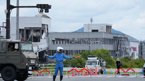 A police officer controls the traffic near AEON Mall, which was destroyed by an explosion following an earthquake, in Kashima, Kumamoto Prefecture, southern Japan, Wednesday, July 29, 2026.  - Sputnik भारत