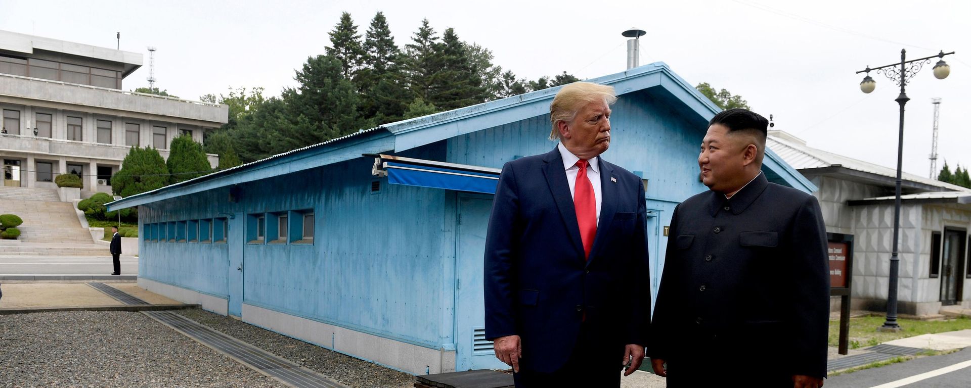 In this June 30, 2019, file photo, US President Donald Trump, left, meets with North Korean leader Kim Jong-un at the border village of Panmunjom in Demilitarized Zone, South Korea - Sputnik भारत, 1920, 04.08.2026