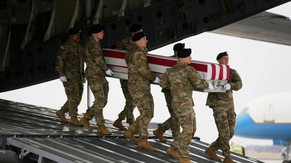 An Army carry team moves a flag-draped transfer case with the remains of Sgt. Declan Coady, 20, of West Des Moines, Iowa, who was killed in a drone strike at a command center in Kuwait after the US and Israel launched its unprovoked military aggression against Iran, past President Donald Trump and first lady Melania Trump during a casualty return, Saturday, March 7, 2026, at Dover Air Force Base, Del. - Sputnik भारत
