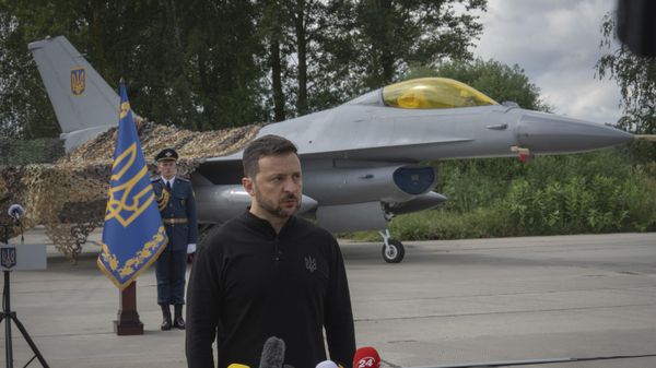 Volodymyr Zelensky answers media questions standing against the background of Ukraine's Air Force's F-16 fighter jets in an undisclosed location in Ukraine, Sunday, Aug. 4, 2024.   - Sputnik India