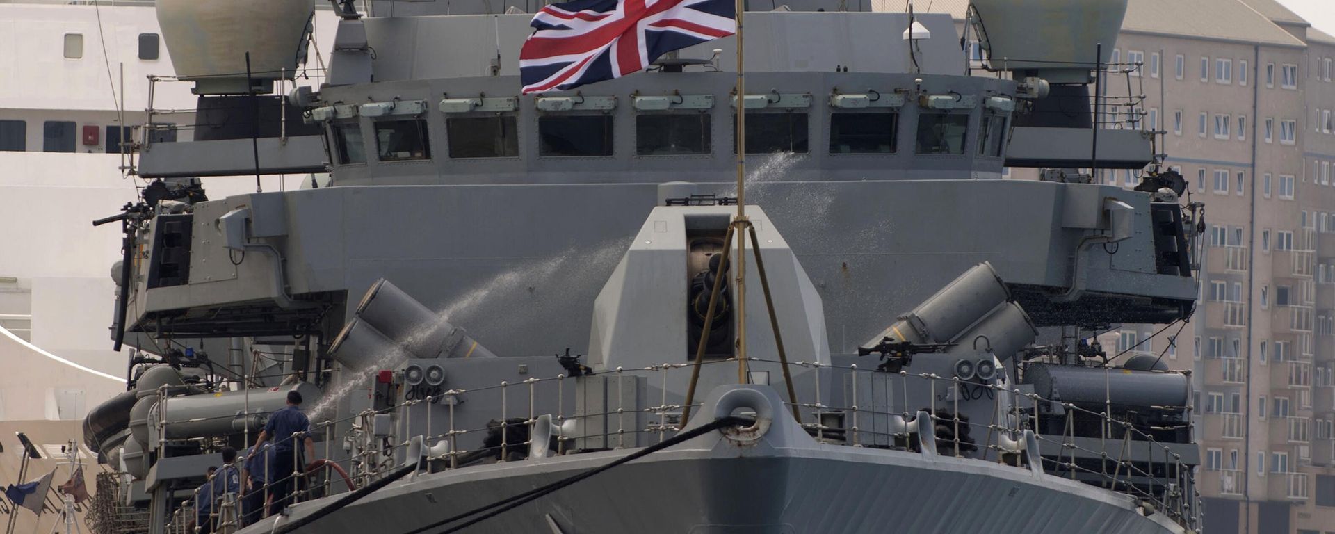 A crew member uses a water hose onboard Britain's Royal Navy warship HMS Westminster in Gibraltar, Monday, Aug. 19, 2013 after the ship arrived for what Britain's government said was a planned naval exercise in the Mediterranean - Sputnik भारत, 1920, 14.10.2026