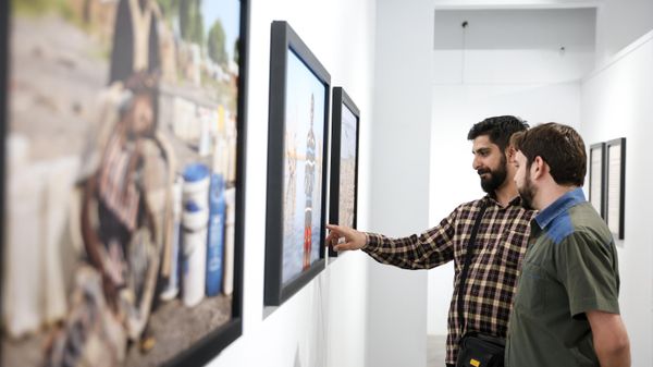 Visitors at the exhibition of laureates of the 2024 Andrei Stenin International Photojournalism Contest in Tehran, Iran - Sputnik भारत